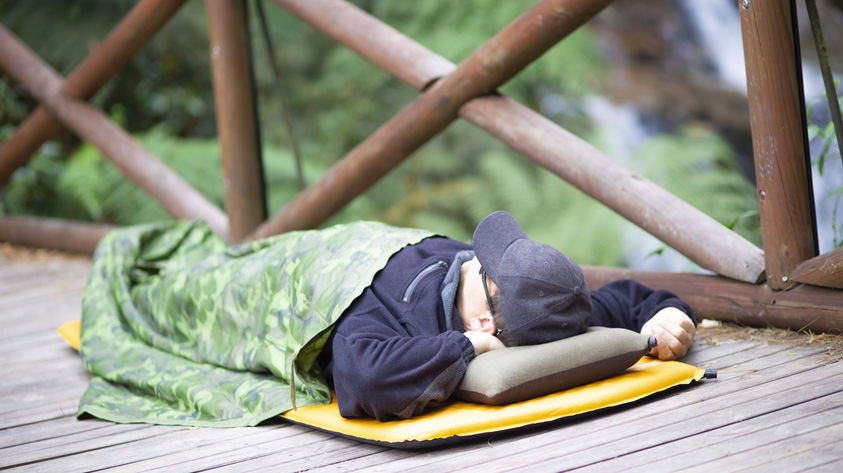 Mann schläft auf selbstaufblasbarer Isomatte